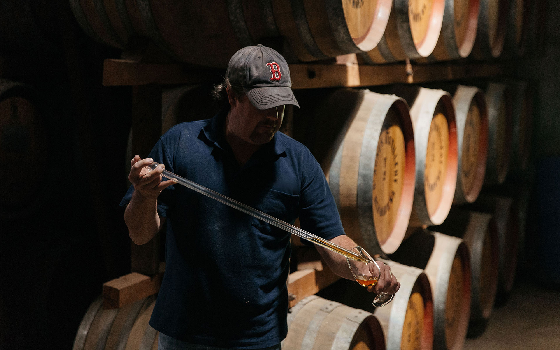 Worker sampling St Agnes spirit from the barrel